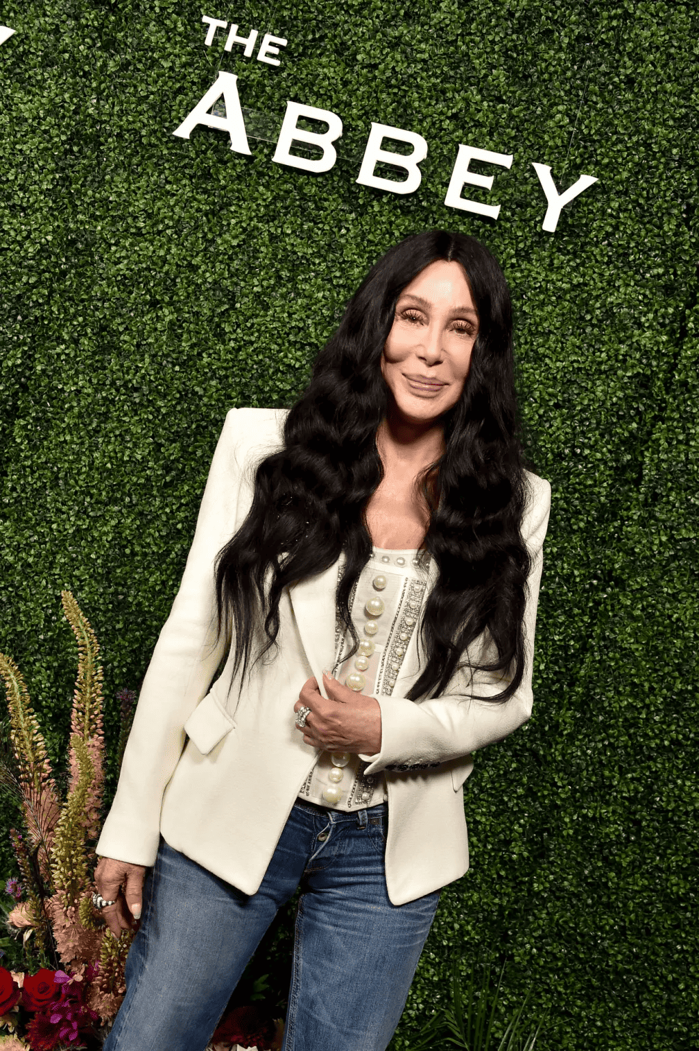 Woman with long black hair smiling at event hosted by Tryst Hospitality at The Abbey venue.