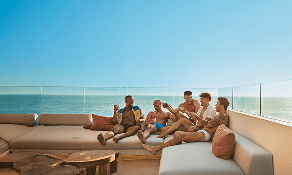 Group of friends enjoying a cruise deck lounge with ocean view.